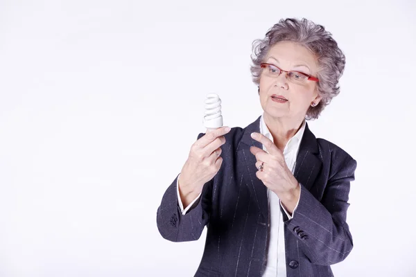 Femme âgée avec ampoule à économie d'énergie — Photo