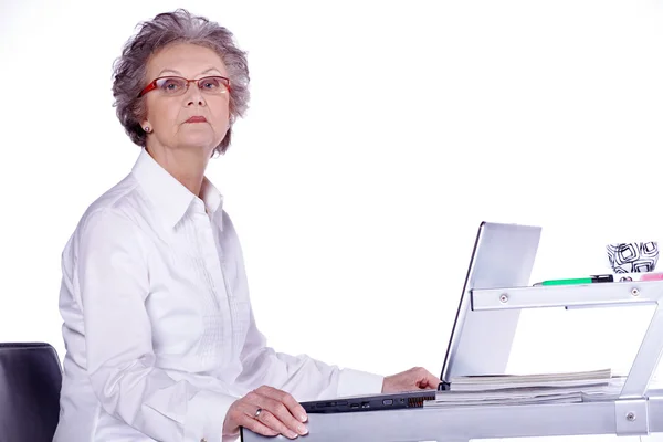 Serious senior woman with her laptop sitting — Stock Photo, Image