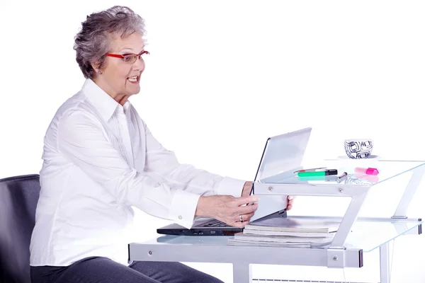 Ernstig senior vrouw met haar laptop zitten — Stockfoto