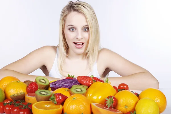 Blond meisje met groenten en fruit — Stockfoto