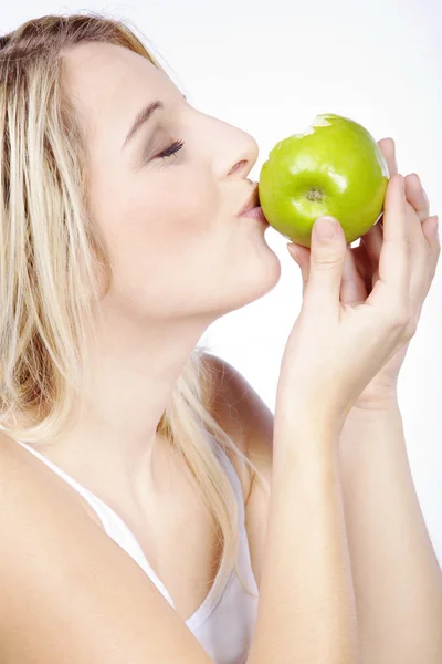 Mulher loira comer maçã verde — Fotografia de Stock