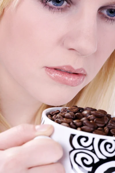 Kahve çekirdekleri tam bir beyaz kahve fincanı tutan güzel bir gülümseme ile çekici genç kadın — Stok fotoğraf