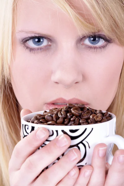 Affascinante giovane donna con un bel sorriso in possesso di una tazza di caffè bianco pieno di chicchi di caffè — Foto Stock