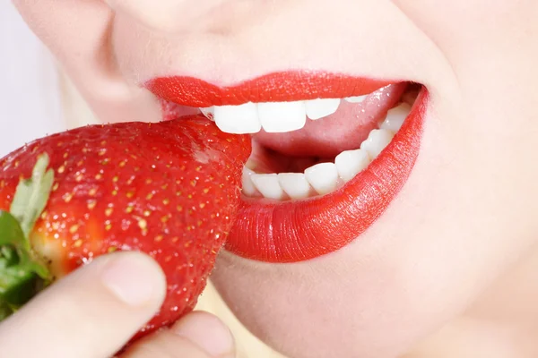 Beautiful female mouth with white teeth eating strawberries — Stock Photo, Image