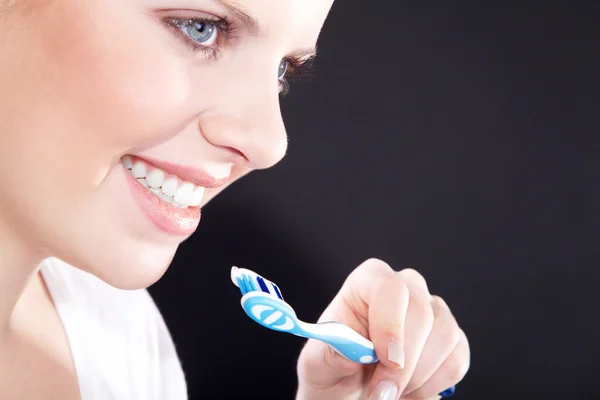 Retrato de cerca de una hermosa mujer joven cepillándose los dientes — Foto de Stock