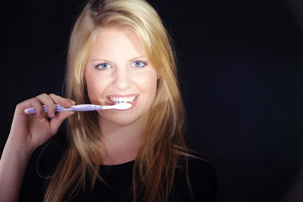 Retrato de cerca de una hermosa mujer joven cepillándose los dientes — Foto de Stock