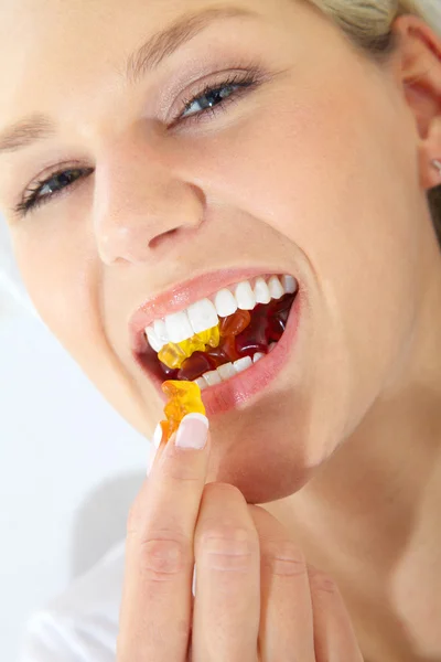 Blonde girl eating marmalade — Stock Photo, Image