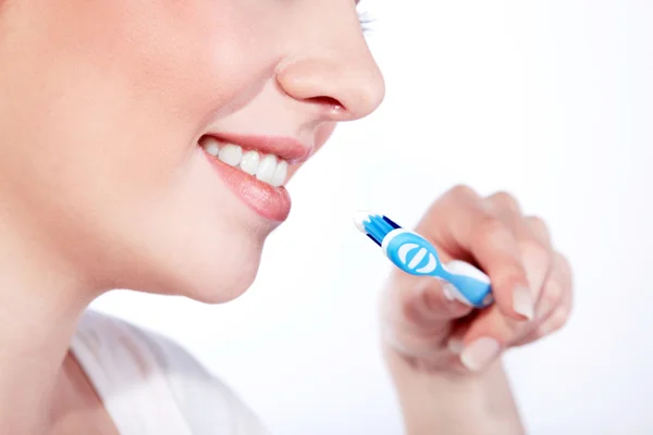Retrato de cerca de una hermosa mujer joven cepillándose los dientes — Foto de Stock