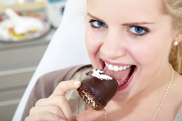 Menina loira comendo chocolate — Fotografia de Stock