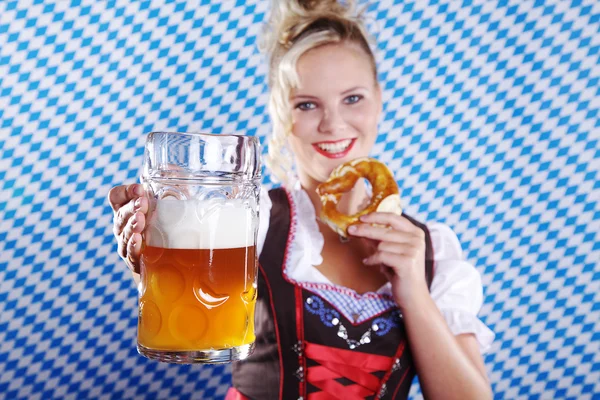 Mujer feliz en dirndl dloth celebración Oktoberfest cerveza stein y pretzel en las manos — Foto de Stock