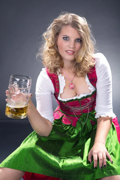 Ung sexig kvinna som bär en dirndl med ölglas — Stockfoto