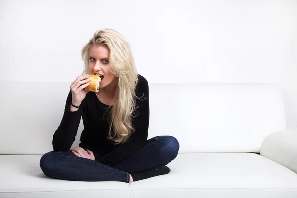 Blonde girl eats bread — Stock Photo, Image