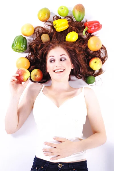 Mulher deitada entre frutas e legumes — Fotografia de Stock