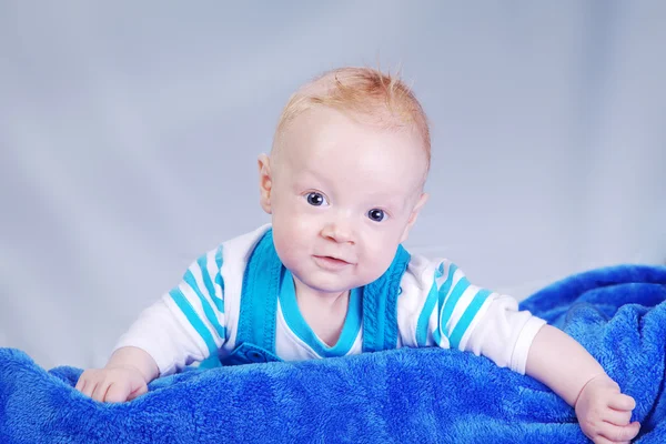 Niño feliz envuelto en toalla azul — Foto de Stock