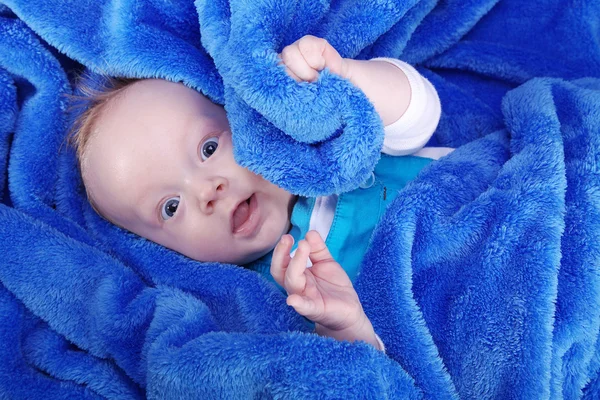 Glückliches kleines Kind in blaues Handtuch gehüllt — Stockfoto