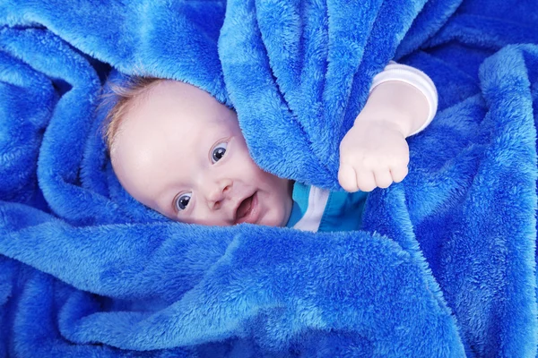 Gelukkig kindje verpakt in blauwe handdoek — Stockfoto