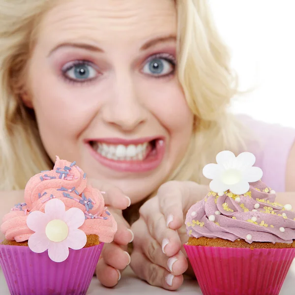Молодая улыбающаяся женщина с кексом — стоковое фото