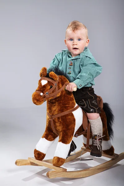 Baby sitzt auf einem Spielzeugpferd — Stockfoto