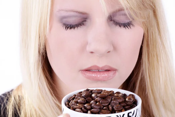 커피 콩의 전체 화이트 커피 컵을 들고 아름 다운 미소와 함께 매력적인 젊은 여자 스톡 사진