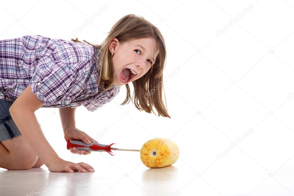 Young girl having fun with paint roller