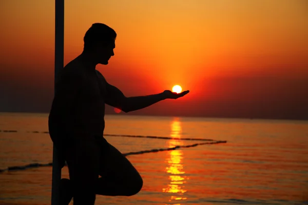 Homem segurando o sol na palma da mão — Fotografia de Stock