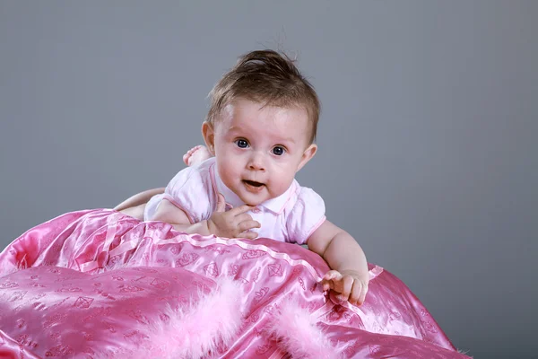 Kleines Mädchen auf einer rosa Decke — Stockfoto