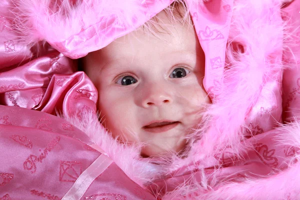 Kleines Mädchen auf einer rosa Decke — Stockfoto