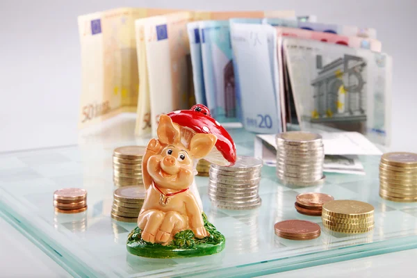 Schachbrett mit Euromünzen und Glücksschwein — Stockbild Schachbrett mit Euromünzen und Glücksschwein — Stockfoto