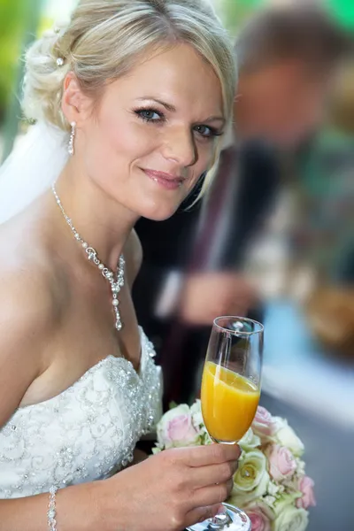 Bride with a bouquet of flowers and a glass — Stock Photo, Image