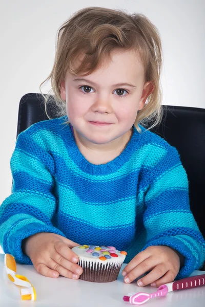 Kleines Mädchen mit Zahnbürste und süßem Essen — Stockfoto