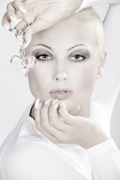 Блондинка с серебряными украшениями в форме сердца — стоковое фото