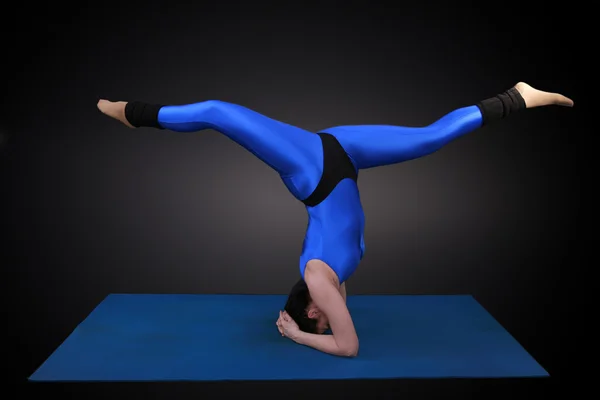 Woman doing yoga headstand-balancing act — Stock Photo, Image