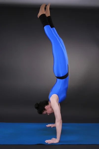 Mujer haciendo yoga handstand — Foto de Stock