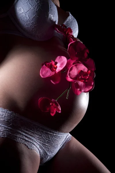 Barriga grávida com orquídea — Fotografia de Stock