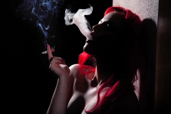 Курящая сексуальная рыжая женщина — стоковое фото