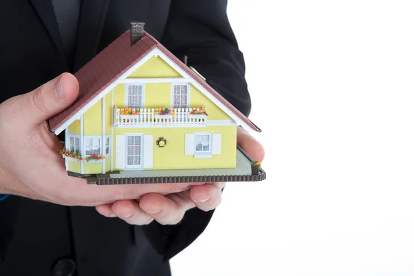 Businessman holding miniature house — Stock Photo, Image