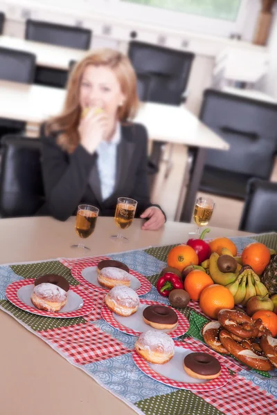 Food on the table in the office on the background of a businesswoman — Stock Photo, Image