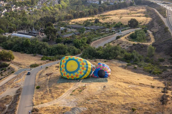 Vista aérea de globos aerostáticos coloridos preparación para el lanzamiento sobre San Diego —  Fotos de Stock