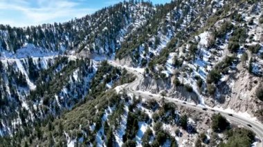 San Bernardino Ulusal Ormanı 'ndaki kar dağındaki yılan yolunun havadan görüntüsü.,