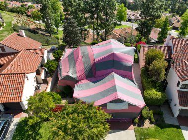 Kaliforniya 'da termitler için dezenfekte edilirken kırmızı ve gri bir çadırla kaplı bir villa.