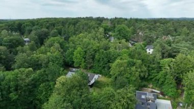 Aerial view of luxury villas with garden surrounded by forest, in the country side area of Walloon Brabant, Belgium