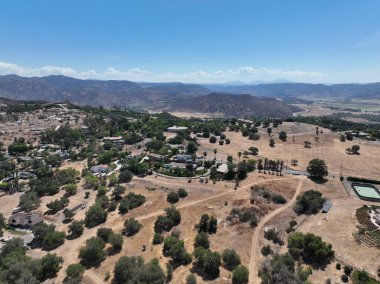 Aerial view of dry valley and land with houses and barn in Escondido, San Diego, California