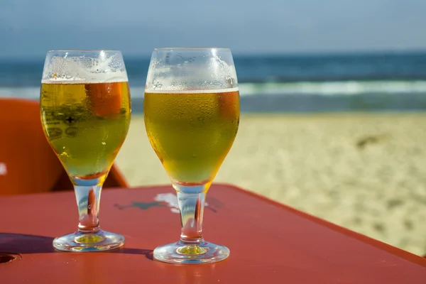 Mavi gökyüzü, kırmızı masa ve bira