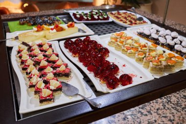 Various desserts in candy bar food buffet during hotel brunch. Self service in hotel restaurant