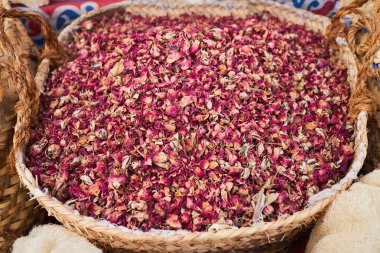 Dried pink rose flowers at the basket. Aromatic petals for tea at the oriental bazaar, Arabic, Turkish and Iranian culture market