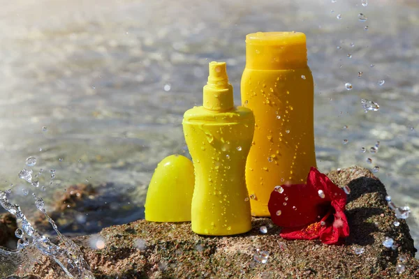Yellow Sunscreen Cream Bottles Skin Protection Red Hibiscus Flower Stone — стоковое фото