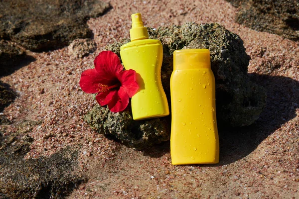 Yellow Sunscreen Cream Bottles Skin Protection Red Hibiscus Flower Stone — 스톡 사진
