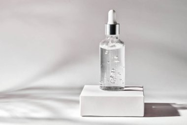 Cilt bakımı özü, emülsiyon ya da gri arka planda damlatıcısı olan cam şeffaf şişe serumu. Sıvı serumu, yüz derisi için vitamin.. 