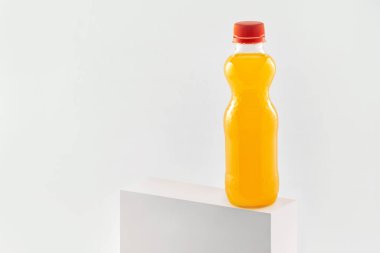 Beyaz arka planda izole edilmiş plastik bir şişede portakal suyu.