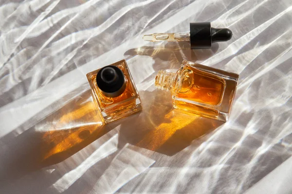 透明油的指甲和角质层护理玻璃瓶与白色背景与自然阴影喷雾器 美容美发概念 — 图库照片